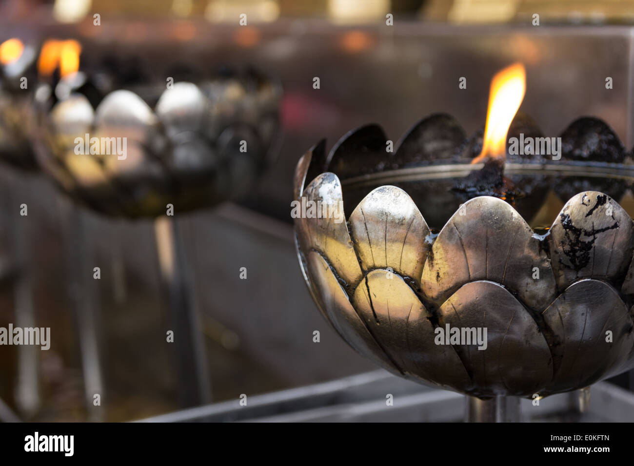 Oil filling in Thai style metal candle in Thai temple, Chiang Mai, Thailand Stock Photo