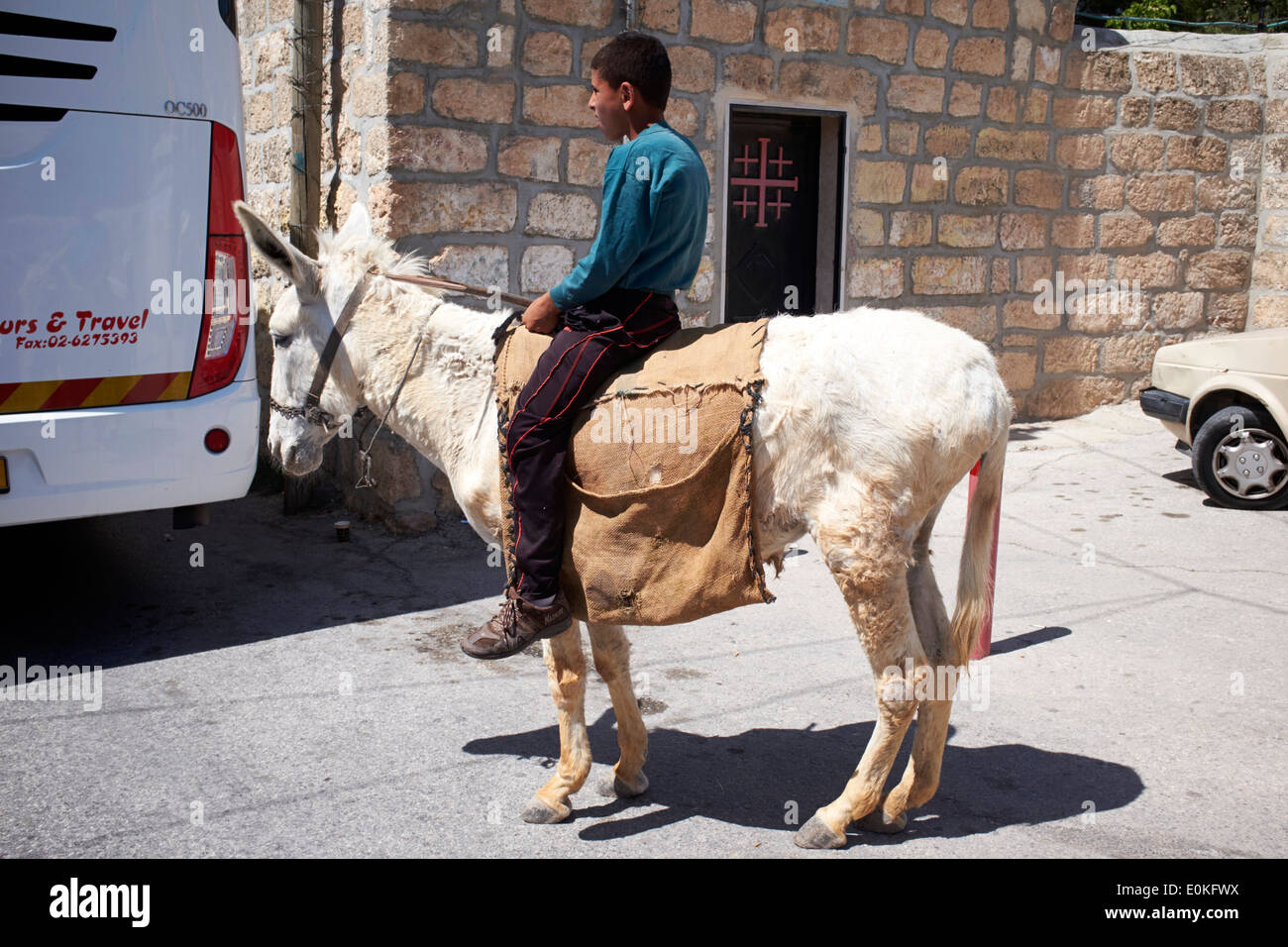 Boy on Donkey outside of The Church of the Shepherds, Bethlehem, West Bank Stock Photo