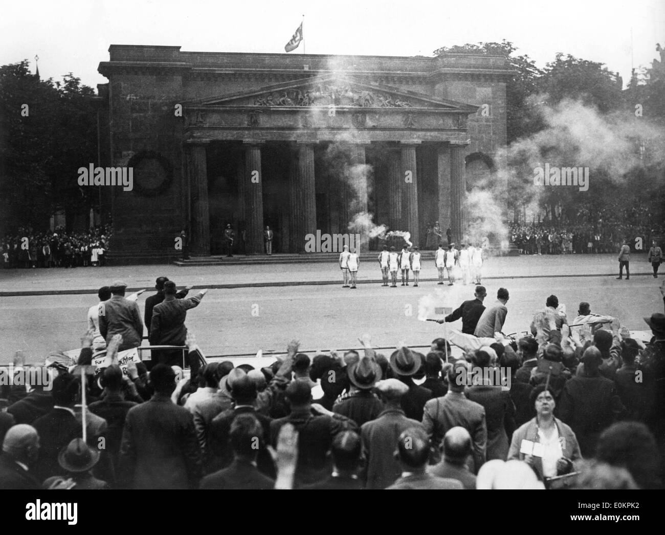 The Olympic Flame Honors the past in front of the Monument of the Death Stock Photo