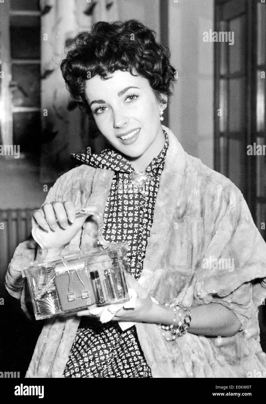 Actress Elizabeth Taylor holding up her purse Stock Photo
