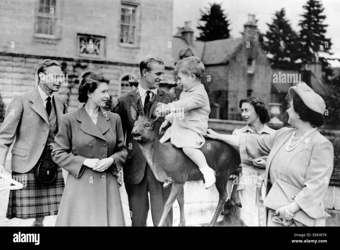 Member of the Windsor royal family gathered around a young Prince Charles sitting on a deer Stock Photo