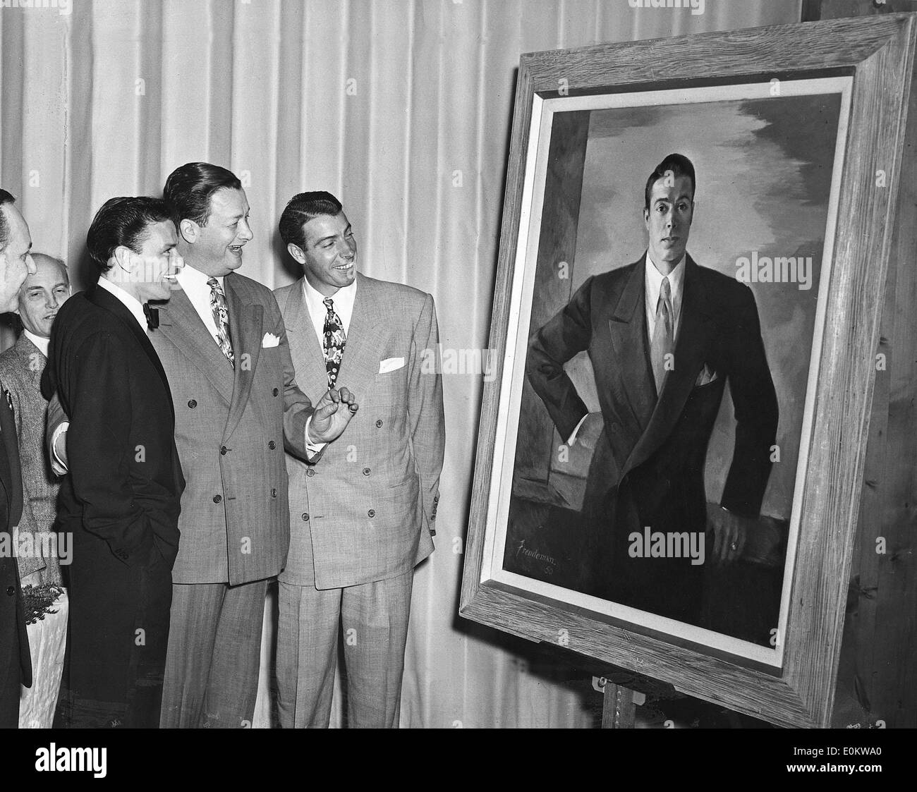 Frank Sinatra, Toots Shor and Joe DiMaggio looking at a portrait of DiMaggio Stock Photo