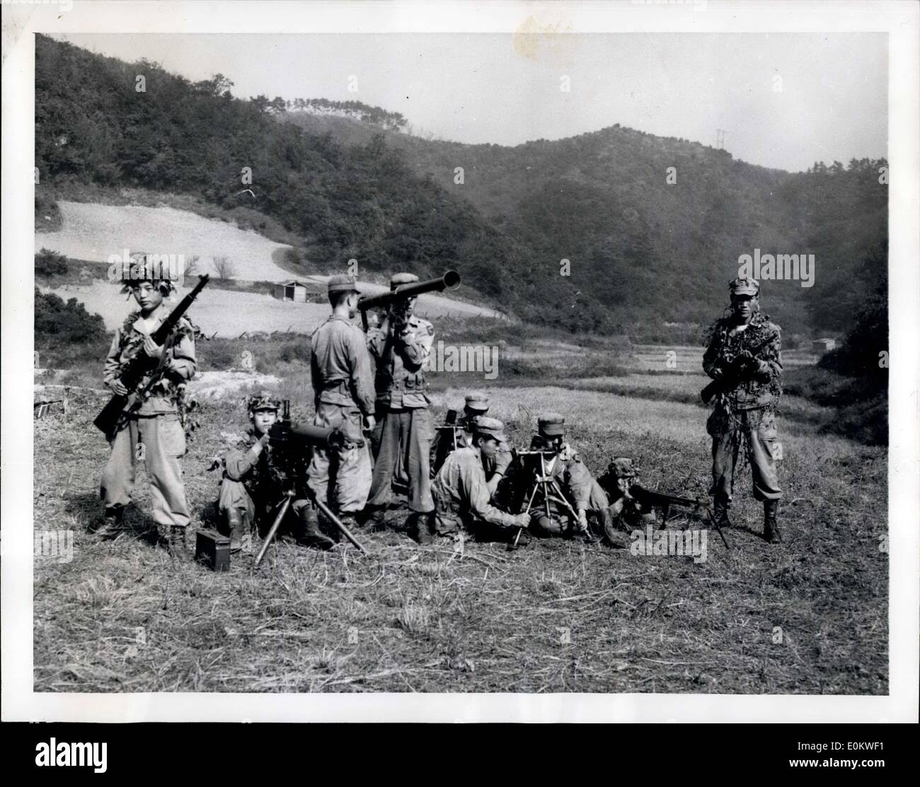 Nov. 07, 1951 - Japan's Police: Arms And The Men Trainees at Japan's National Police Reserve Academy in Etchujima pose behind their varied weapons on one of the school's firing ranges. About 950 trainees are at the academy undergoing a nine-week training course. Their weapons include the M-1 rifle, the carbine, 30-caliber and 50-caliber machine guns, the 2.36 bazooka, the 60mm mortar, the Browning automatic rifle. Mortars and bazooka are recent additions to the police arsenal. Stock Photo