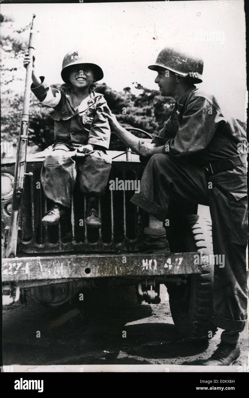 Oct. 10, 1950 - Korean mascot. Photo shows Little Joe, a South Korean orphan adopted by a medical company of the 25th Infantry Division U.S. Army proudly displays a captured North Korean weapon to Col. Joseph Sennice, of Schenectady, NY. Stock Photo