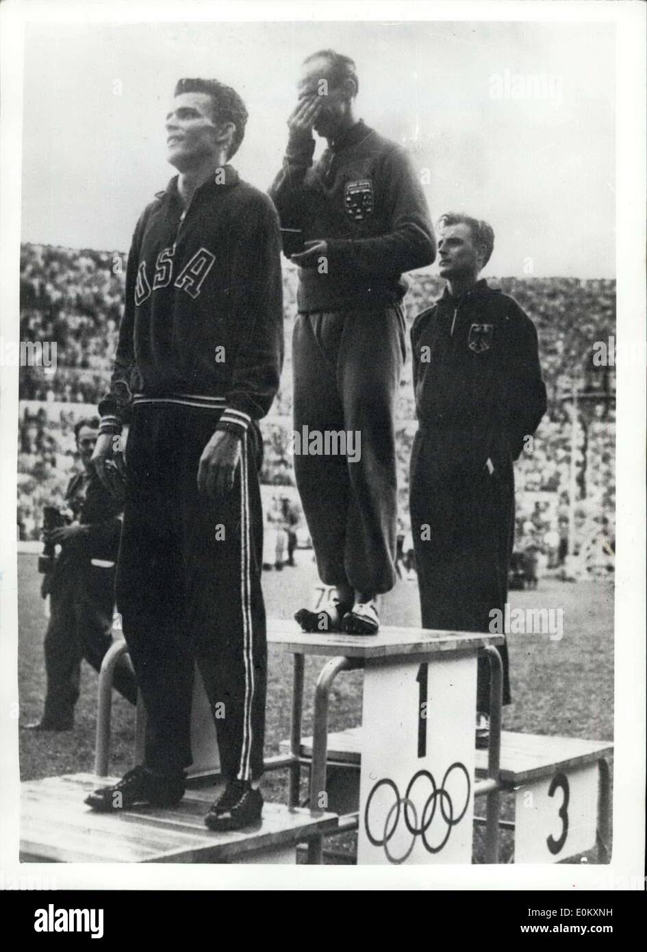 Jul. 26, 1952 - Barthel Of Luxemburg Weeps On The Winner's Stand After Winning 1500 Metres Final At Helsinki. Photo shows J. Barthel of Luxemburg weeps with emotion on the winner's rostrum after winning the 1500 Metres final at Helsinki today. In front is R.E. McNillan (USA) who came second and behind is W. Lueg of Germany who came third. Stock Photo