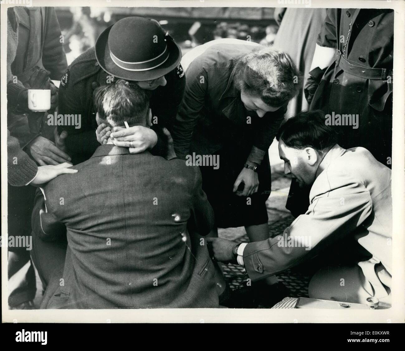 Oct. 10, 1952 - Many Killed in Triple Train Disaster doctor attends to a victim: It is estimated that the death roll may even be as high as 100 following the triples train rash at harrow and wealdstone station this morning. The crash was between the night Scot to Esuto - the Easton to Liverpool express - and a local watfored to London train. One of the trains ploughed into the station platform and the bridge over the wesldstone high steer collapsed. photo shows An ambulance worker comforts one of the victims while a doctor attends to him after the disaster at harrow today. Stock Photo