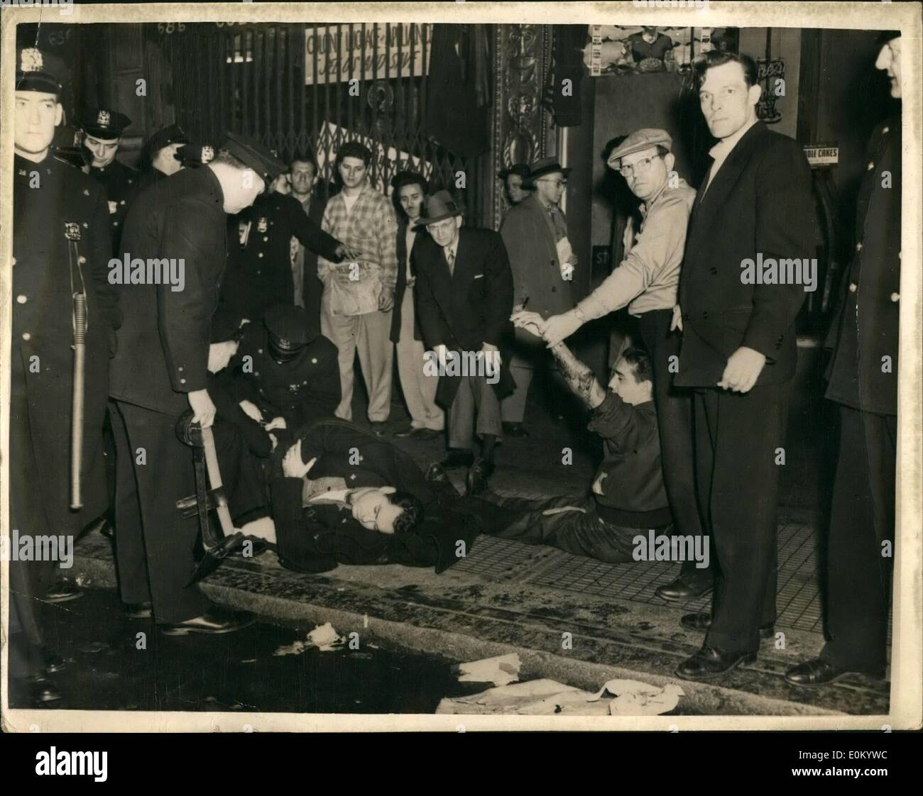 Dec. 12, 1952 - New York Cops In Gun Battle.. Seven Including By-Stander Injured.. Two men, Charles Mason and Richard Linquist got into a fight outside a bar at 675 Eighth dt up and a moment later Clarence Sims, a Cleveland dsperado and Cecil Johnson drove up with the intention McAuliffe arrived and hearing that Sims was armed - backed him against the wall. The arrival of two more patroman Knox and conlon, diverted McAuliffe's with three slugs.. The thugs fled in a heil of lead and wild gun battle ensued. Stock Photo