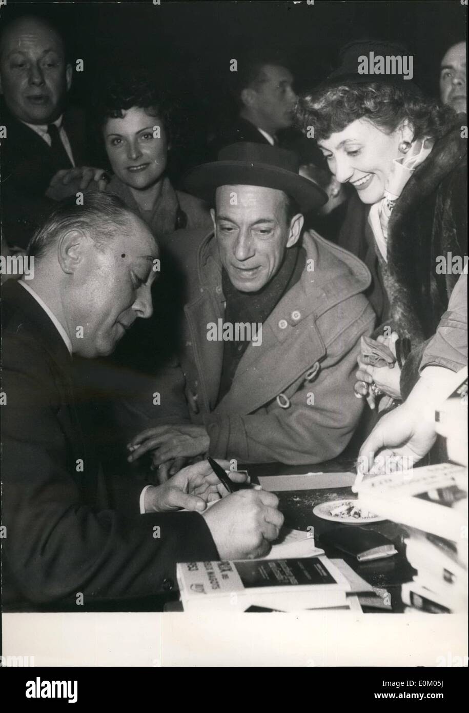 Feb. 02, 1953 - 'Slang' Author Autographs His Book In A ''Tough Joint'': Albert Simonin, The French Author who is specialised in underworld characters and writes his novels in slang autographs his latest book at the famous night cabaret ''Bal A Jo'' in the Rue De Lappe, supposedly a ''Tough Section'' of Paris. Looking on are Raymond Bussiers, screen actor and Annette Poivre. Stock Photo