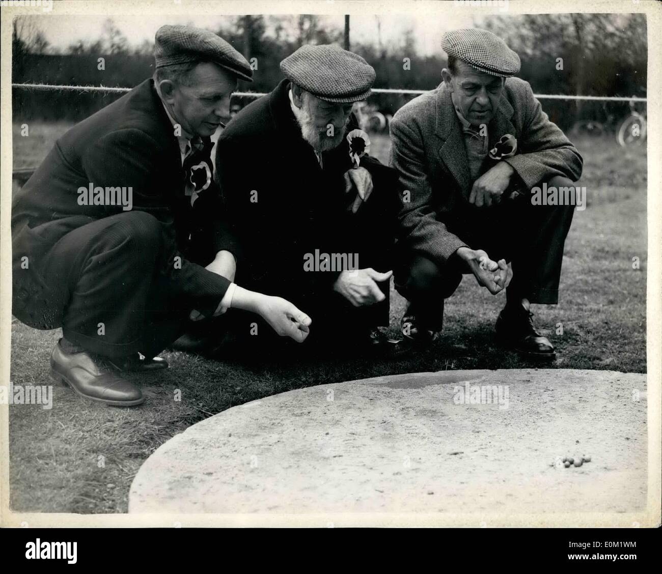 Apr. 04, 1953 - Annual Marbles championship at Tinsley Green... The annual good Friday marbles championships took place this morning at the village of Tinsley Green, on the Surrey-Sussex border. The contest goes back to Armada days when two village swains competed for the hand of a maiden in a game of marbles.... Photo shows:- Left to right:- George Maynard, aged 50: Pop Maynard, aged 81: and Arthur Maynard. aged 52, who are members of the Coptherne Spitfire seen in action during the match this morning. Stock Photo