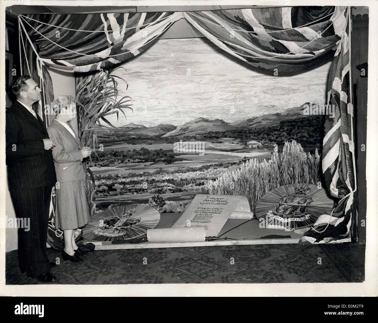 May 13, 1953 - Coronation Window Display By Australian Artists. Design In Wool At Queensland House: A press preview was held this afternoon at Queensland House, Strand - of the Coronation Window Display - the work in wool - by Australian artist Edith Kenton from Adelaide. Photo shows Edith Kenton stands with the Australian Agent General David John Muir - at Queensland House this afternoon. The whole display, including the flag drapings - the picture and the badges and emblems are all worked in wool. Stock Photo
