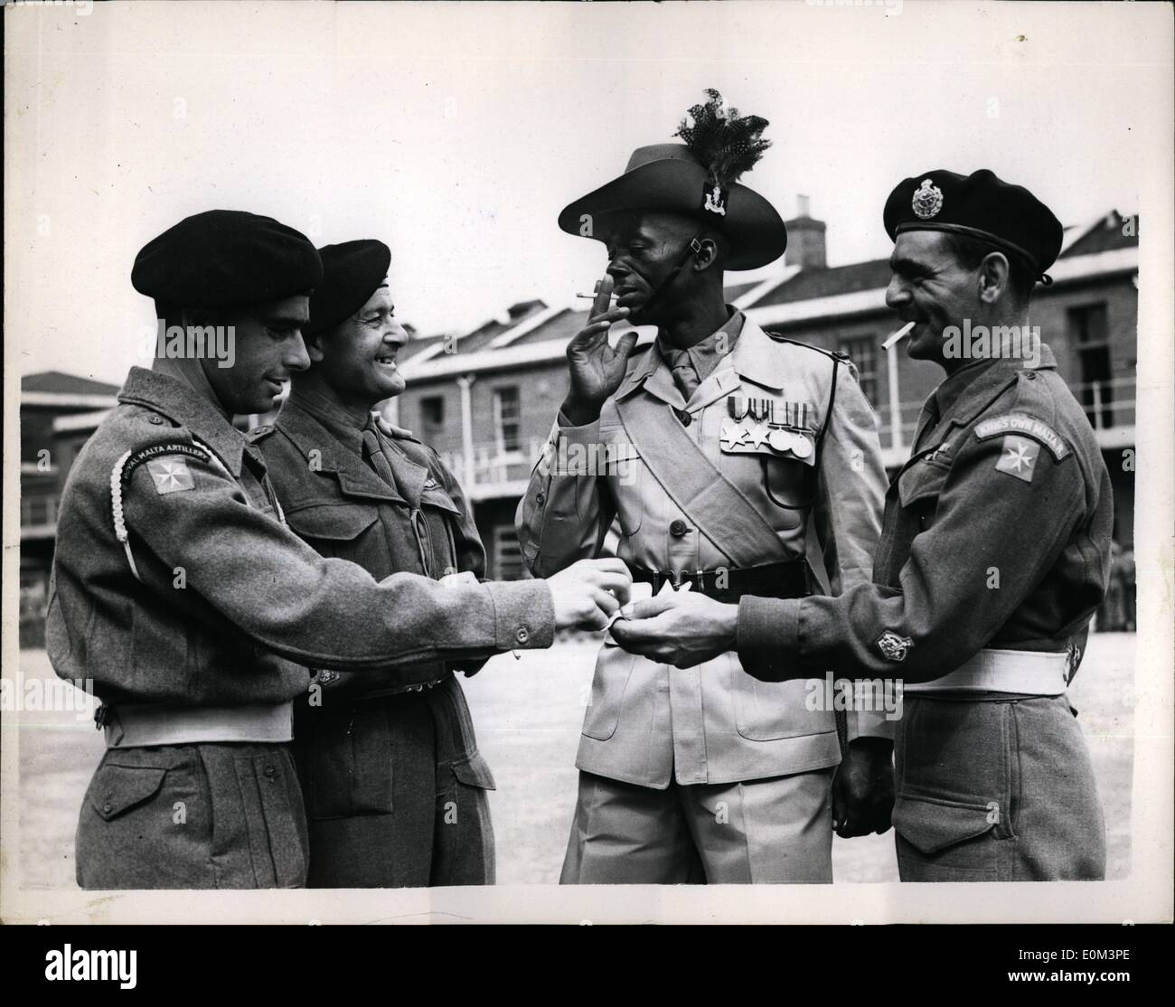 May 05, 1953 - Colonial Coronation Contingent at Woolvich.: Members of the Colonial Corporation contingent which will number about 500 and be representative of almost all dependent territories - who will take seen this morning at the Royal Artillery Depot, at Woolwich. Photo shows Thee members of the Maitese detachment chatiing to W.C John Popo, of the 2nd. King's African Rifles, at Woolwich today. The Maltese are (L to R.) Gnr. T. Feeri; B.S.M. A. Attard, and G.S.M. Tony Gaira (extreme right) Stock Photo