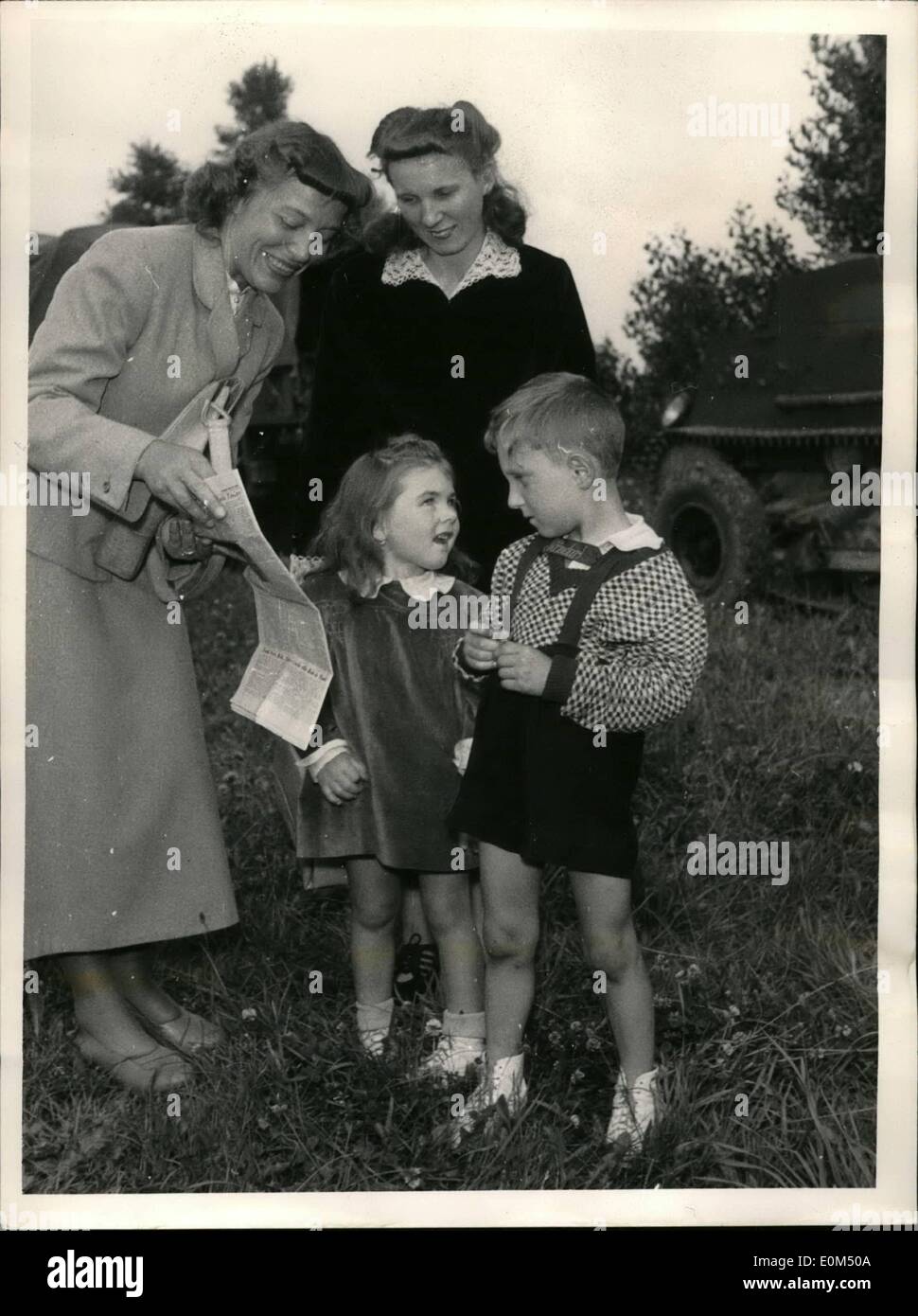 Jul. 07, 1953 - Czech refugees now given asylum - happily liberated. : Happily smiling after thorough army screening are the eight Czech refugees who crashed the Czech-German Border on 25 July 1953, at 0430 hours, at Haselbach, rural district Waldmuenchen (Bavarian Forest), Southern Germany. Photo shows Mrs. Cloude, Mrs. Uhlik and their two children. here they are seen studying the paper with the headlines reporting about their self-liberation. Exclusive. Stock Photo