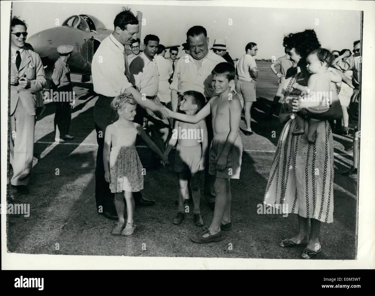 Sep. 09, 1953 - Attempt On World Air Speed Record: Picture taken in Libya, where an attempt is likely to be made this week to break the world speed record recently set up by Neville Duke. This attempt will be made by the Vickers Supermarine ''Swift'', piloted by Mike Lithgow. Photo shows Lithgow being greeted by young Michael Metcalfe on his arrival at the RAF station, Castel Idris. Also seen are Diane Booker & Rodger Metcalfe, with Mrs. Booker (who is the wife of an RAF officer) Stock Photo