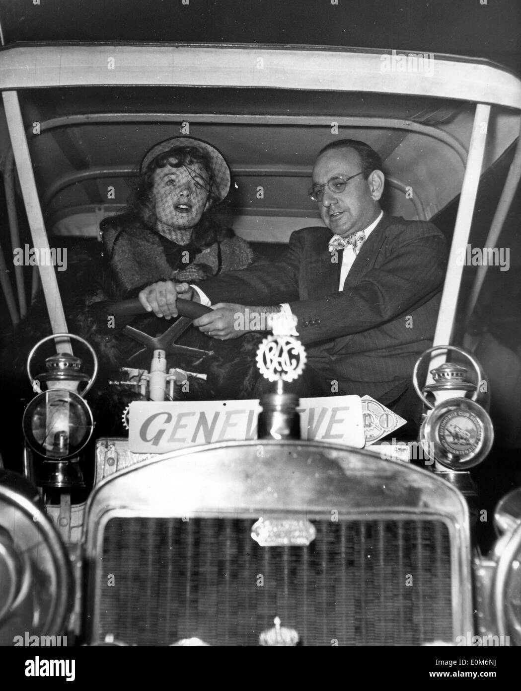 Oct 30, 1953 - London, England, UK - (File Photo, location unknown) HENRY CORNELIUS was a South African who worked as a director, editor, producer, writer of films in Britain. PICTURED: HENRY CORNELIUS, right, with French actress ETCHIKA CHOUREAU, in the taxicab used in his film 'Genevieve'. Stock Photo