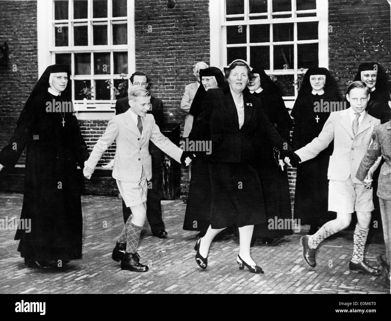 Queen Juliana dances with orphans at the orphanage Stock Photo