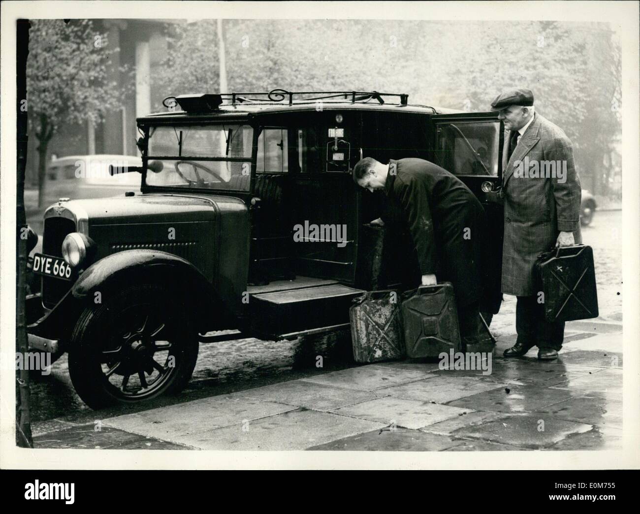 Oct. 10, 1953 - Petrol Strike Threatens to Halt London: Empty Petrol tanks face London and the Home Countries this morning as the result of the unofficial strikes of 6,000 Petrol-tanker drivers. Ministers were meeting today to prepare emergency plans to use troops to distribute petrol if the strike continues. Photo Shows Taxi-drivers Ernest coeling (left) and R. Horne are seen loading a taxi-cab with ''Jerry'' cans full of petrol from a Clapham garage, one of the very few who still had Supplies. Stock Photo