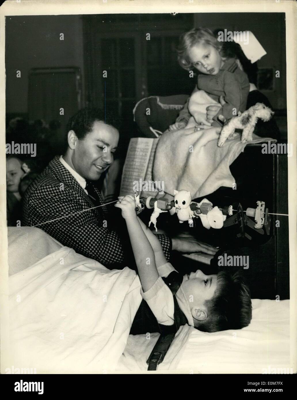Nov. 11, 1953 - American ''Guys and Dolls'' Star visits infantile paralysis Hospital: American Actor Jerry Wayne who is starring in ''Guy's and Dolls'' - and who was once a Polio victim - this morning paid a visit to the Queen Mary's Hospital, for Children - at Carshalton - where he talked and sang for some of the children. Photo Shows Jerry Wayne singing to Stewart Hand (4) while seated at the piano at the hospital today. The Child was flown from Malaya for treatment. Seated on top of piano is Linda Hillary (3) who comes from Sutton. Stock Photo