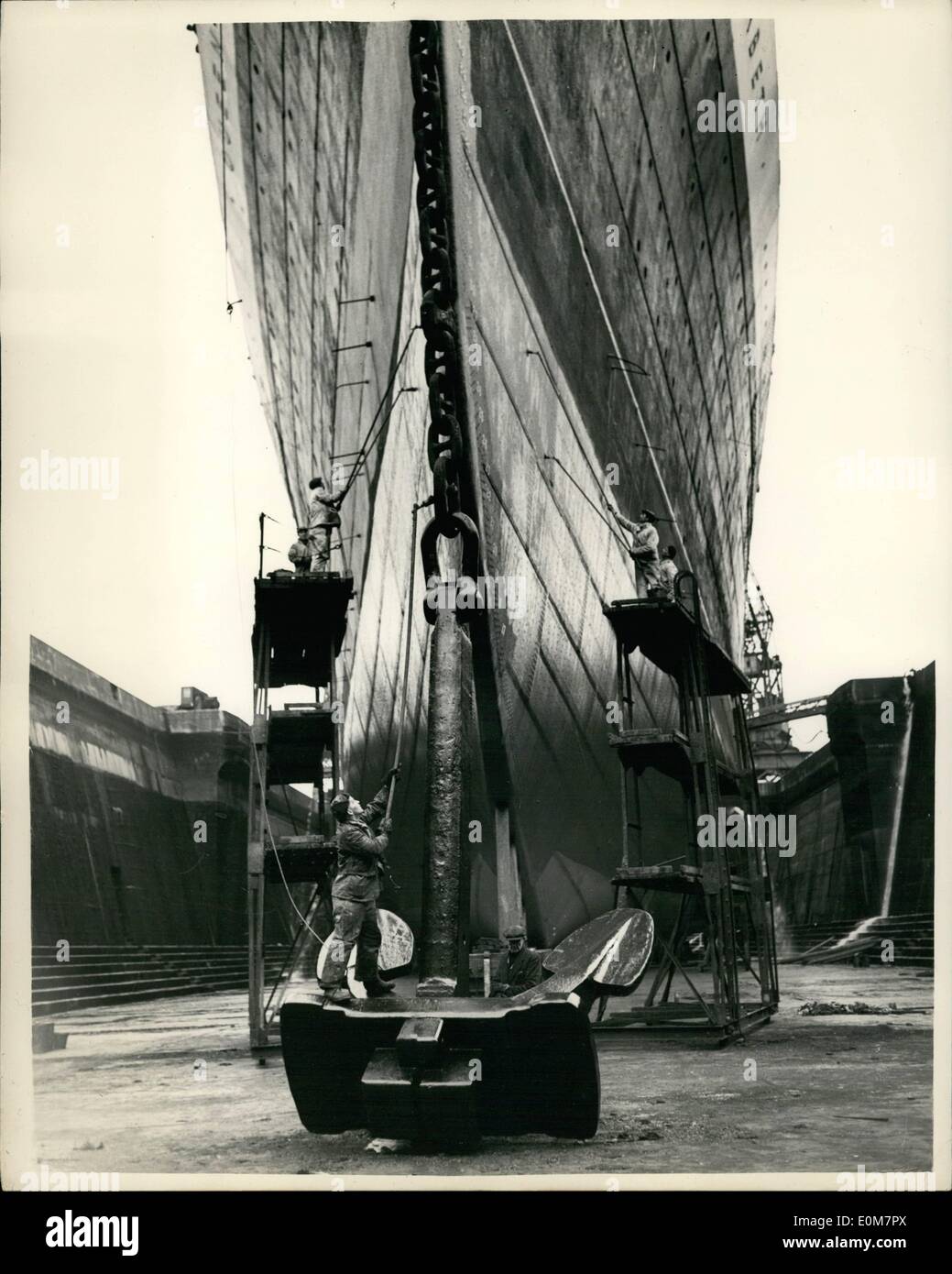 Jan. 01, 1954 - ''Queen Elizabeth'' in Dry Dock: The Liner Queen Elizabeth is now in King George V Dock at Southampton, where she is undergoing her annual overhaul. Photo shows the giant anchor is receiving attention, as the sides of the liner are painted at King George V Dock at Southampton. Stock Photo