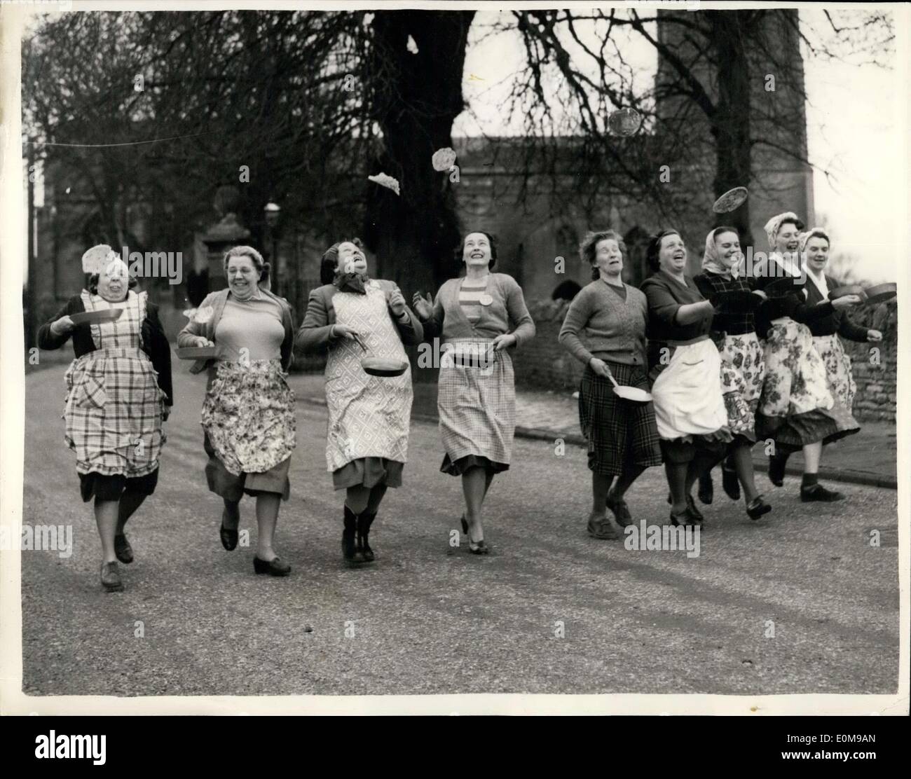 Feb. 25, 1954 - Women-prepare for pancake race: Women contestants in thi year; Shrovetide Pancake race in the old market town of Olneym Burks, are busy practicsing for the race, which takes place nest Tuesday. this year, an old rule of this 500-years old evert is to be revived. Competitors will have to toss their pancakes not once-but three times-at the start, at the finish and half-way while running. Photo shows A line-up of some of teh competitors at teh start of a practice run at Olney today. They are: (L to R): Miss Marjorie Well, Miss Mary wells, Miss W.P ''Illegible'' Burtt, Mrs Stock Photo