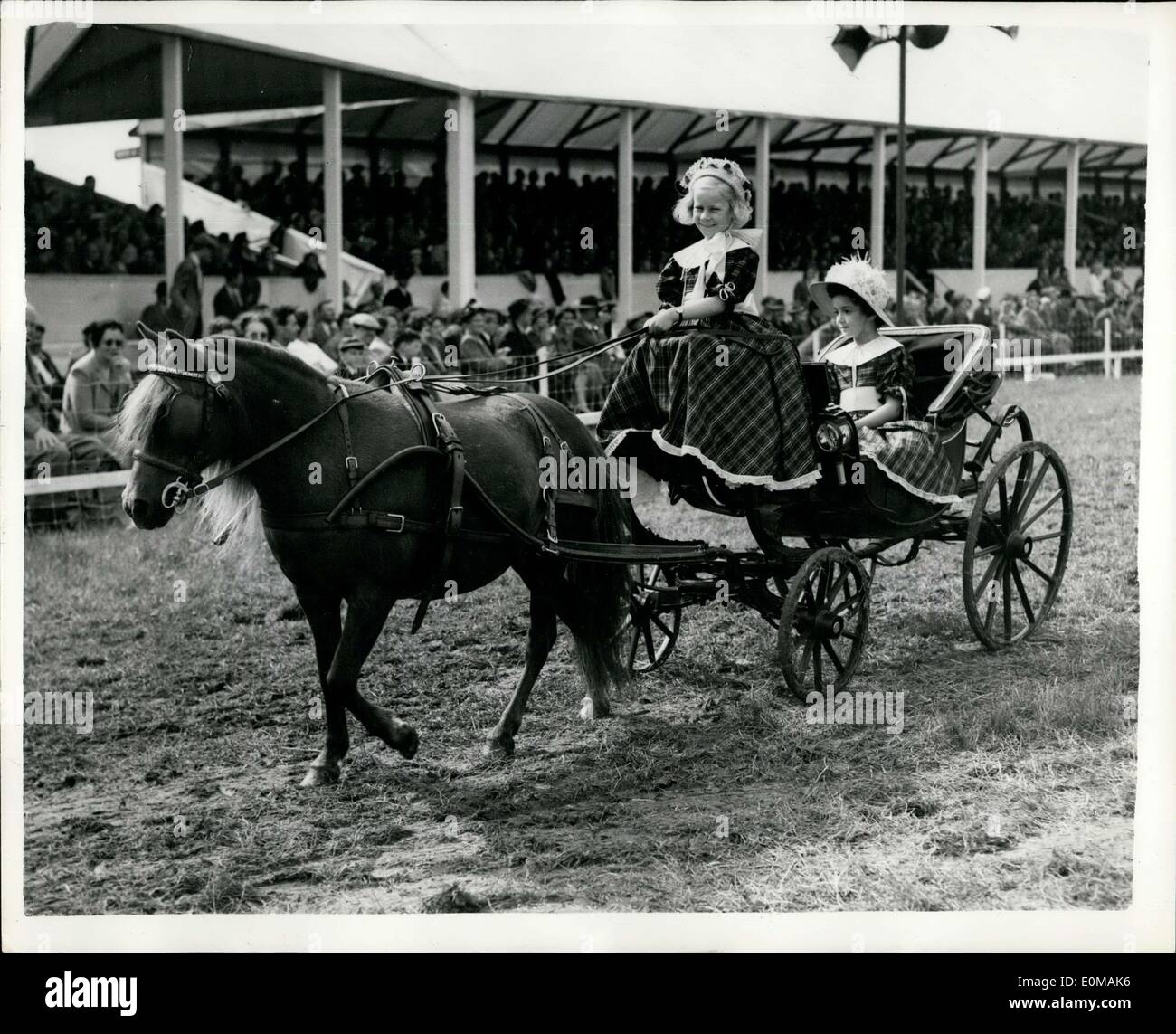 Jul. 06, 1954 - Royal show Opens At Windsor: Photo shows In costumes of the Victorian period these two children, 7-year-old Mary Rose Peddie (driving) and 7-year-old Tessa Cole, both of Tring, Herts. drive Queen Adelaide's Miniature Barouche, loaned by H.M. the Queen, during the parade of Ancient and Historic vehicles. Stock Photo