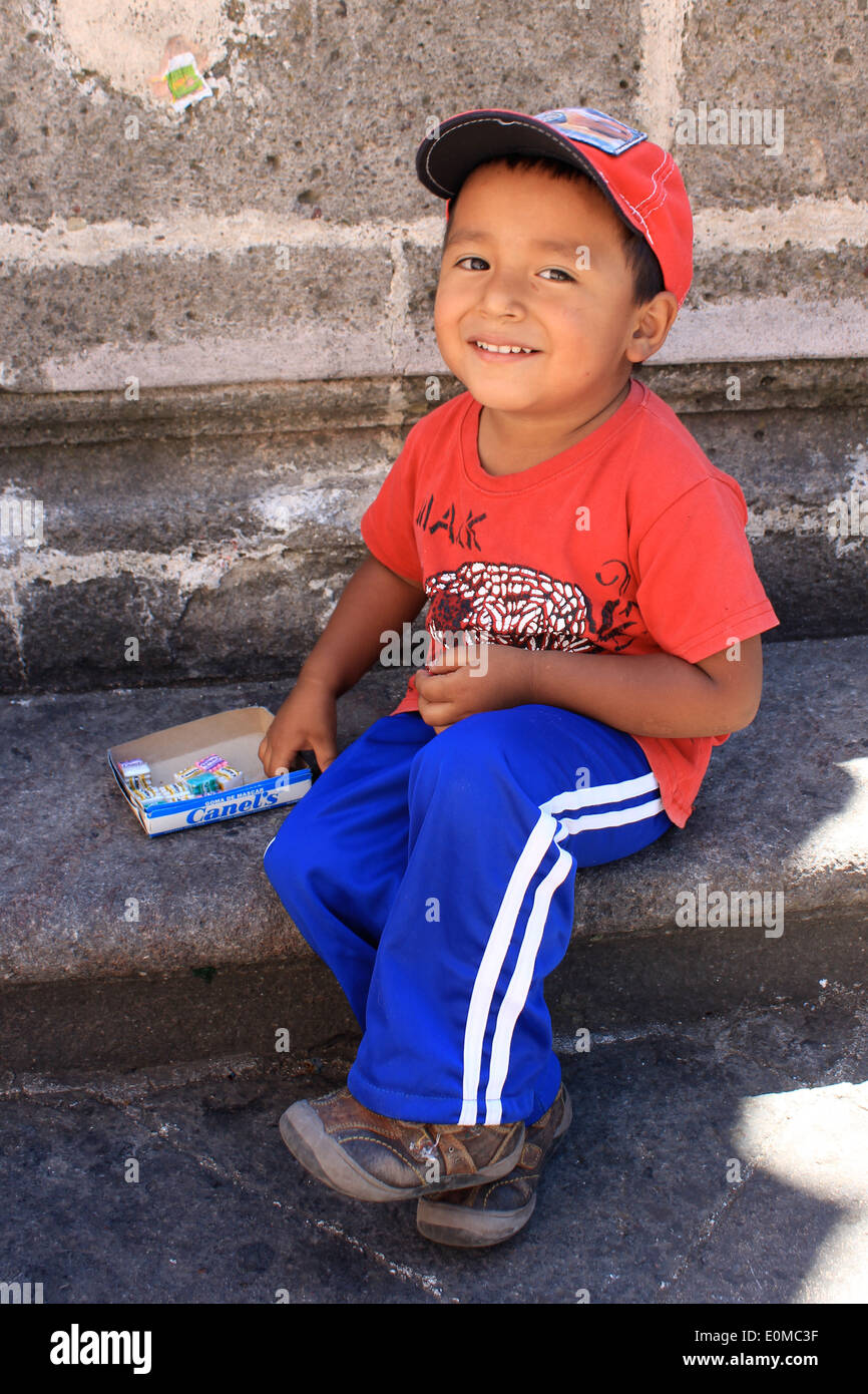A small Mexican boy selling chewing gum outside the church of Santa Prisca in Taxco, Mexico Stock Photo