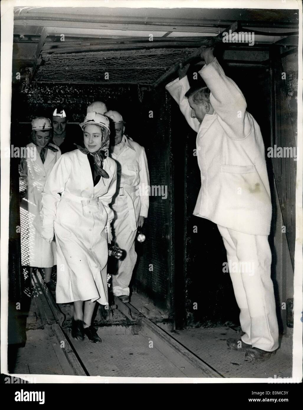 Aug. 08, 1954 - PRINCESS MARGARET GOES DOWN A MINE. Wearing a white helmet and white overalls PRINCESS MARGARET stepped into the cage of Britain's super-de-luxe colliery at Calverton, near Nottingham, yesterday. Then she descended1,158 feet down the shaft to watch the miners at work. PHOTO SHOWS: Up swings the gate of a cage-lift, held against the roof Atlas-wise by Mr. Douglas Pickering, a miner. Princess Margaret leaves the lift, white-overalled, white-helmeted, miner's lamp in hand. She had just finished an hour's to of the pit. Stock Photo