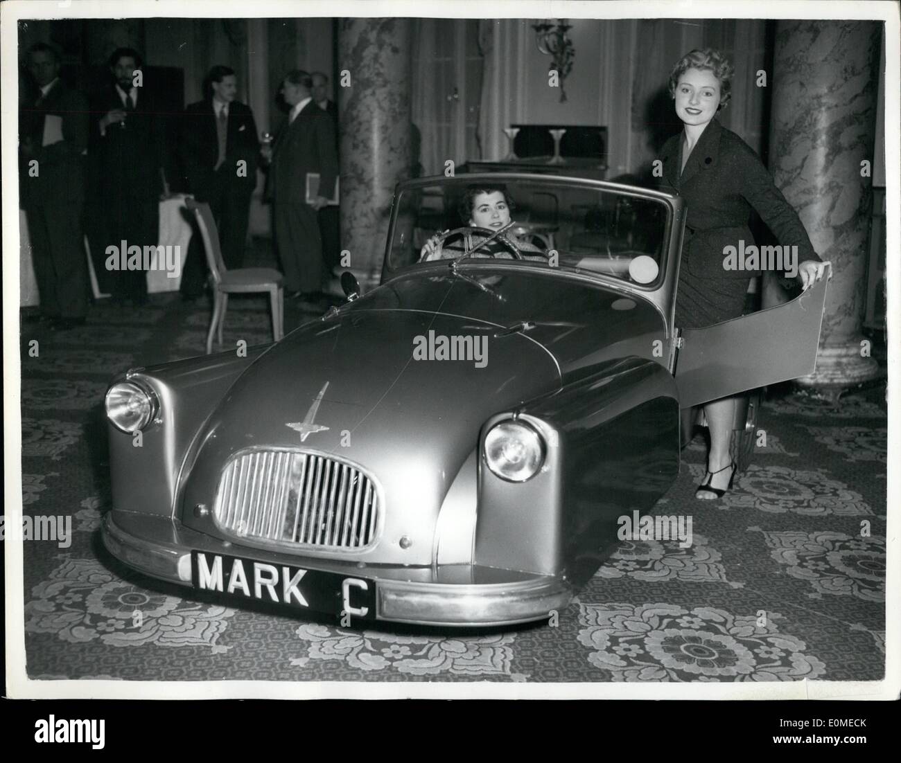 Nov. 11, 1954 - New Version Of The Famous ''Bond Minicar'' On Show.. Can Seat Five In Comfort: The 1955 version of the famous Bond Minicar was to be seen at the Waldorf Hotel this evening. Known as the ''Family Safety Model'' - the two adults and three children. It has a speed of 50 m.p.h. at 85 -90 miles per gallon. The body is now mainly of dent resisting fibreglass plastic.. Built by Sharp's Commercials Ltd. Lancs - the car standard model is priced at  284 -10-5d. and the de-luxe model at 299 - 15 -Od. both inclusive of tax Stock Photo