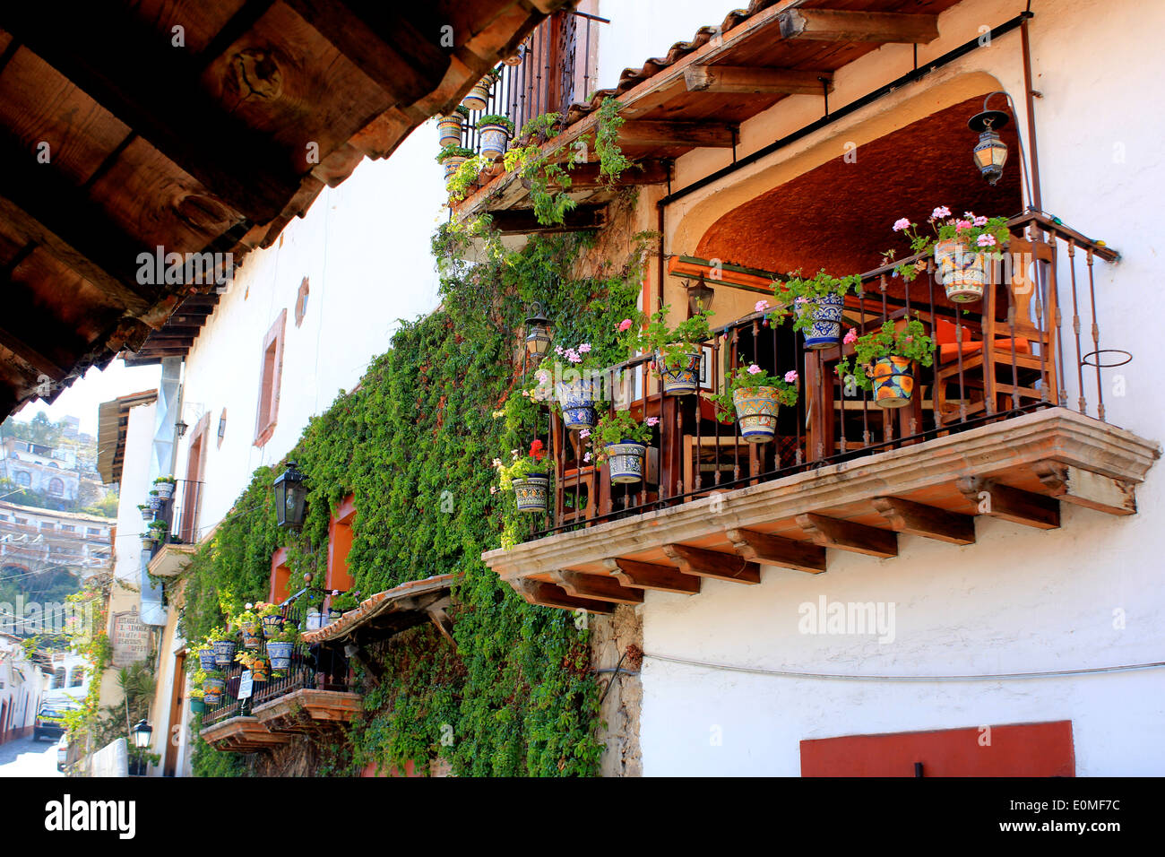 Wooden balcony filled with ceramic pots and flowers in Taxco, Guerrero, Mexico Stock Photo