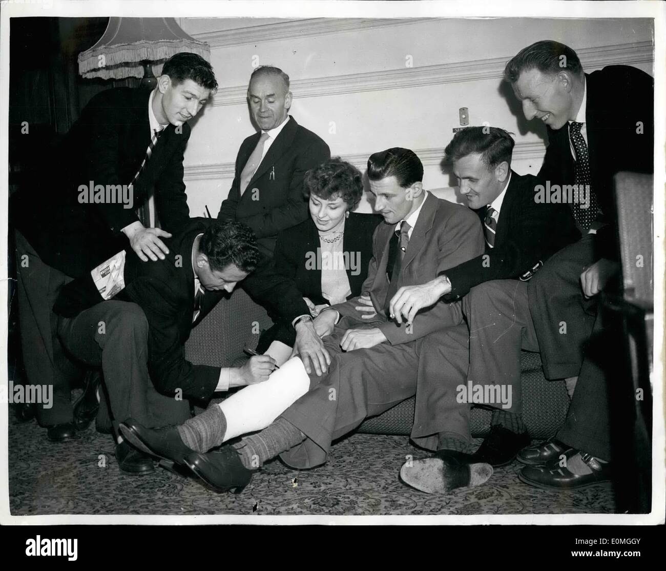 May 05, 1955 - Colleagues autograph the plaster cast. Manchester city player may be out of football for good.: Nineteen minutes, after the start of the Manchester City - Newcastle Cup Final on Saturday - Jimmy Meadows wrenched his knee. He was off the field for the rest of the match.Examination of the injury showed strained ligaments - and his leg has been put in plaster. It is quite possible he may never be able to play football again Stock Photo