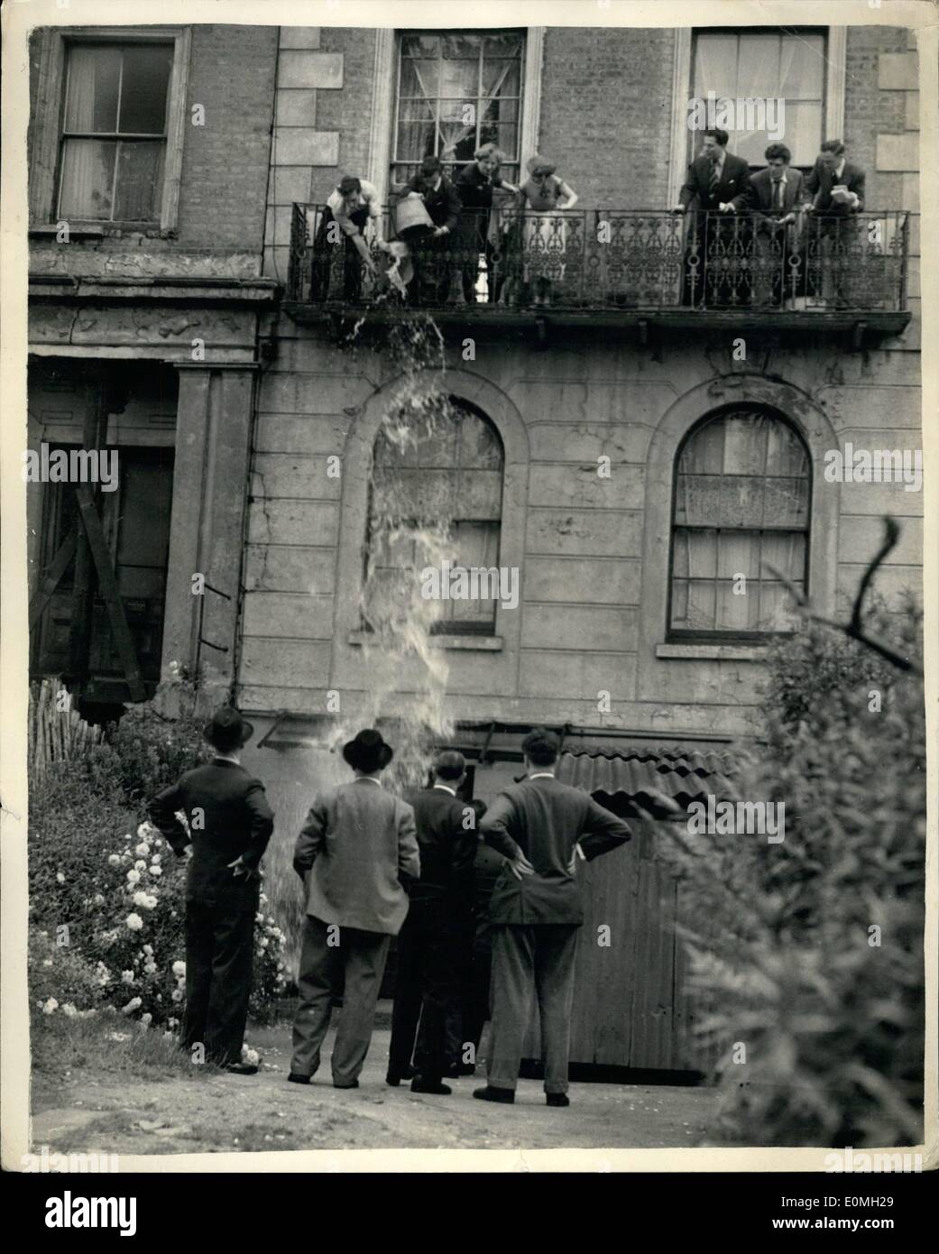 Jul. 07, 1955 - Bailiffs Break Into The House of Siege..Five Year Struggle in Streatham Ends.. A crowd of onlookers watched when police and bailiff's men broke into the home of the Corbettis family at Streatham Hill   thus ending the five year struggle between the family and the L.C.C.. The four-storey house was holding up the completion of a block of new flats - and it had been purchased by the L.C.C. - but the family refused to leave.. Members of the family threw buckets of water over the police and bailiffs before entry into the house was gained. Stock Photo