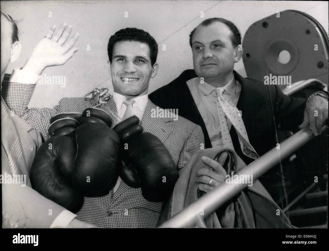 Jul. 07, 1955 - Off to Johannesburg: Robert Cohen (centre), the famous French Boxer, gloves, a cheery goodbye and a happy smile, on the gangway of an air France plane bound for Johannesburg on right his manager Gaston Charles-Raymond. Photo shows  bourget   held this afternoon. Robert Coehn is to fight Willy Tower in a title bout at Johannesburg September 3rd. Stock Photo