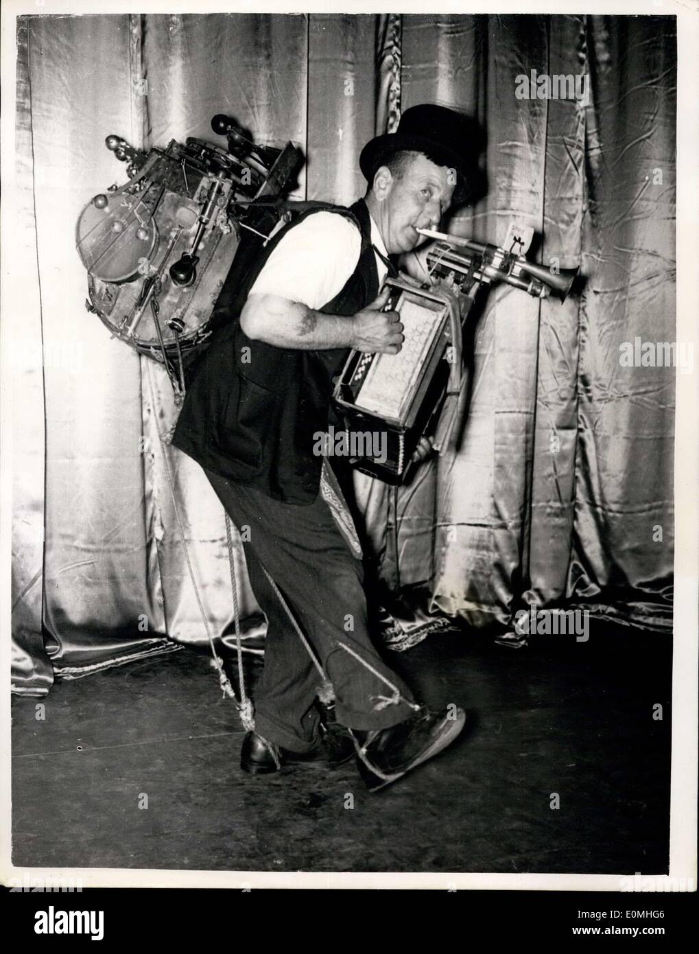 Jul. 28, 1955 - Introducing''Old George'' - The One-Man-Band..A Television Star of the Future?: One of the most popular of the many 'Buskers' to be seen outside the Theatres of the West End of London these days is Old George Wilson who operates a 'One-Man-Band'- in which he plays practically everything but the 'Kitchen sink'..with the Big Drum on his back connected to cymbals-triangles-small drums and many other items with varying tones - and to the front an accordian and a battery of trumpets - Old George gives a performance second to none. Stock Photo