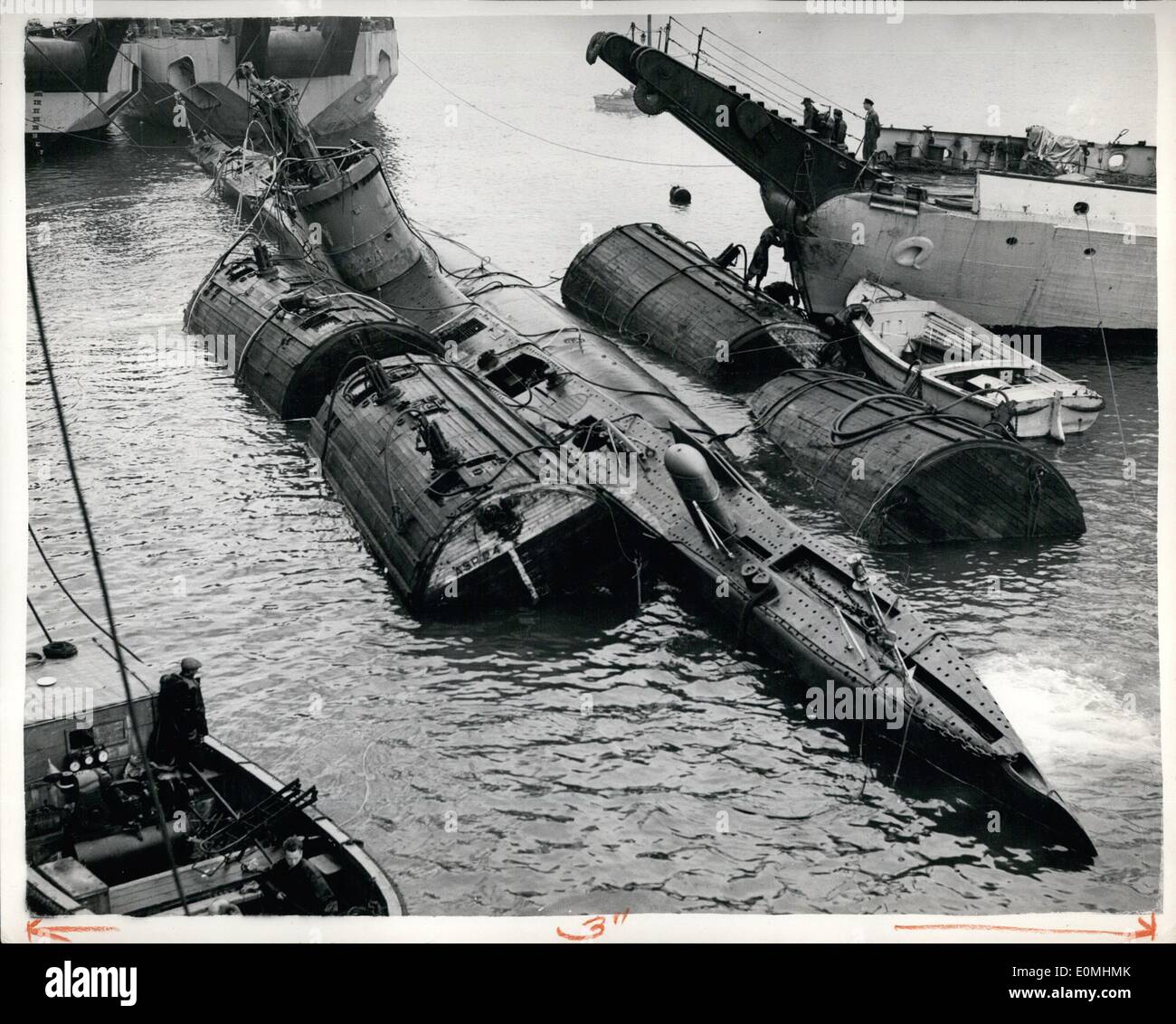 Jun. 06, 1955 - The Sunken Submarine Surfaces in Portland Harbour.: Submarine Sidon surfaces - a week after she had plunged to the bottom of Portland Harbour following an explosion. After surfacing she was moored alongside the mother ship Maidstone. No attempt will be made to get inside her until she is beached today. Photo shows The mud-covered hulk of the submarine Sidon is afloat once more secured to the giant bouyancy tanks which were used in the 21-hour battle to raise her. Stock Photo