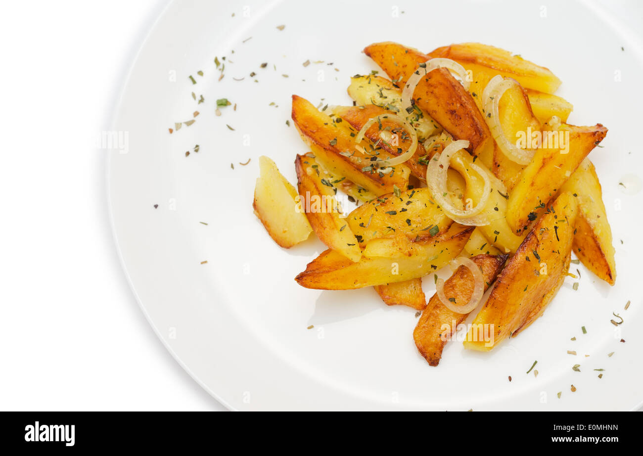 Roasted potato wedges garnished with herbs in white plate isolated on white background. Stock Photo