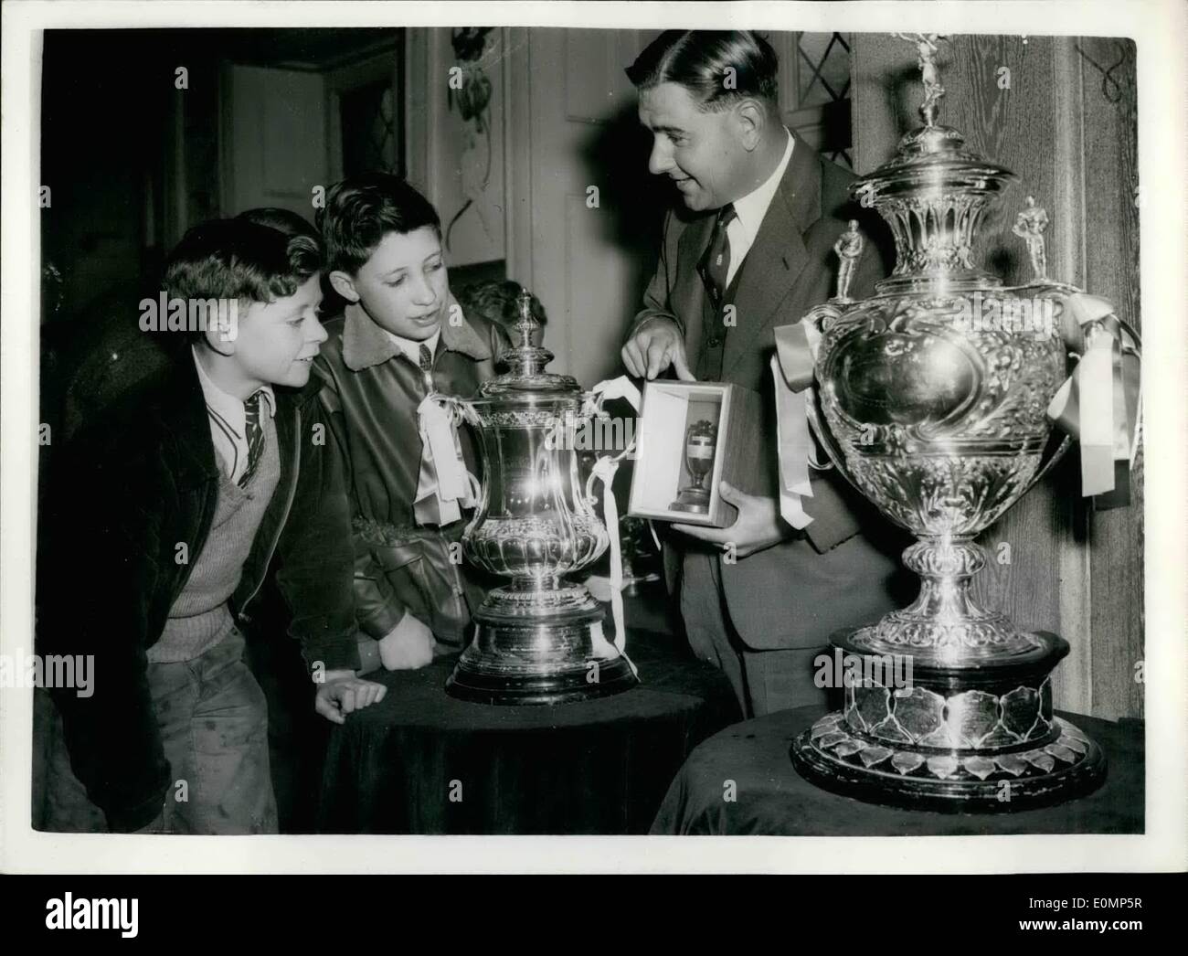 Apr. 04, 1956 - Sports trophies on show in London: The national association of Boy's clubs are holding an exhibition at the cafe Anglais, at which some of Britain's greatest sports trophies are on shows photo shows Colin cowdry, the famous cricketer, who opened the exhibition is seen showing the ashed to Alfred wick, 14, on left, and Robert burnand, 14, of the Brunswick boy's club, fulham. On either side of the ashes can be see the f.a cup (left) and the rugby league cup (right) Stock Photo