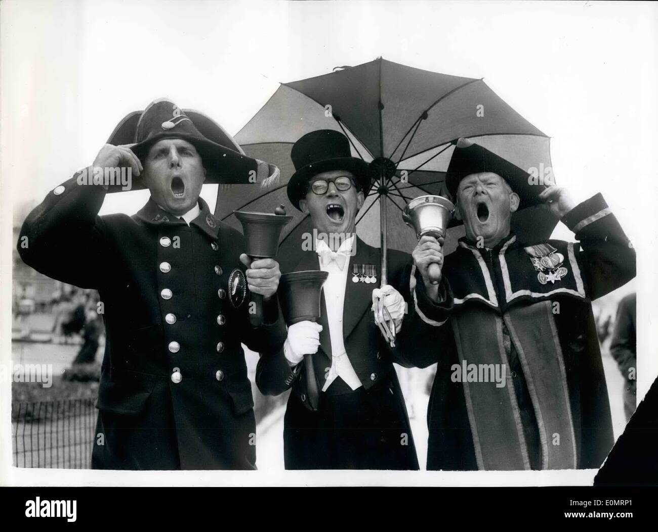 Aug. 08, 1956 - National Town criers championship: The ''news of the world'' National town criers' championship, took place today at Hastings. Keystone photo shows Three of the competitors shelter under an umbrella at Hastings today. (L to R) John Davies, Town crier of wells, somerset: Alfred Howard, of sundown, shanklin, Isle of wight, and Beriie Maunder, of callington, Cornwall. Stock Photo