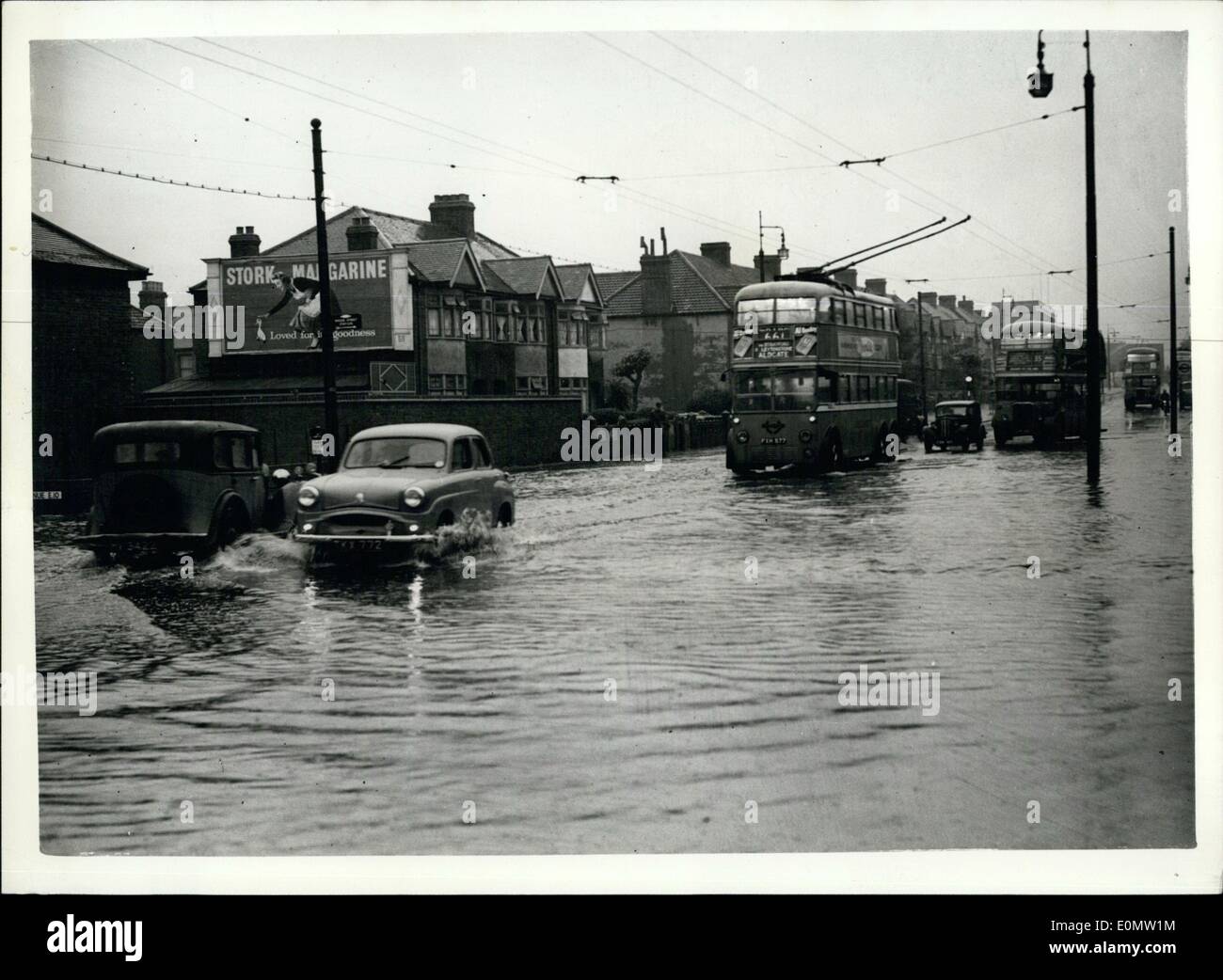 Jul. 07, 1956 - Many London Homes Hit By Lightning And Streets Flooded In Worst Thunderstorm This Year. The worst thunderstorm this year raged for hours over London and the Home Counties today. It left a trial of havoc across Southern England. Many homes were hit by lightning, and there were widespread floods. Rail, road and telephone services in the London area were disrupted, and road traffic was delayed. Photo Shows:- Typical of almost every London district today - flooded streets at Lea Bridge Road, Whipps Cross. Stock Photo