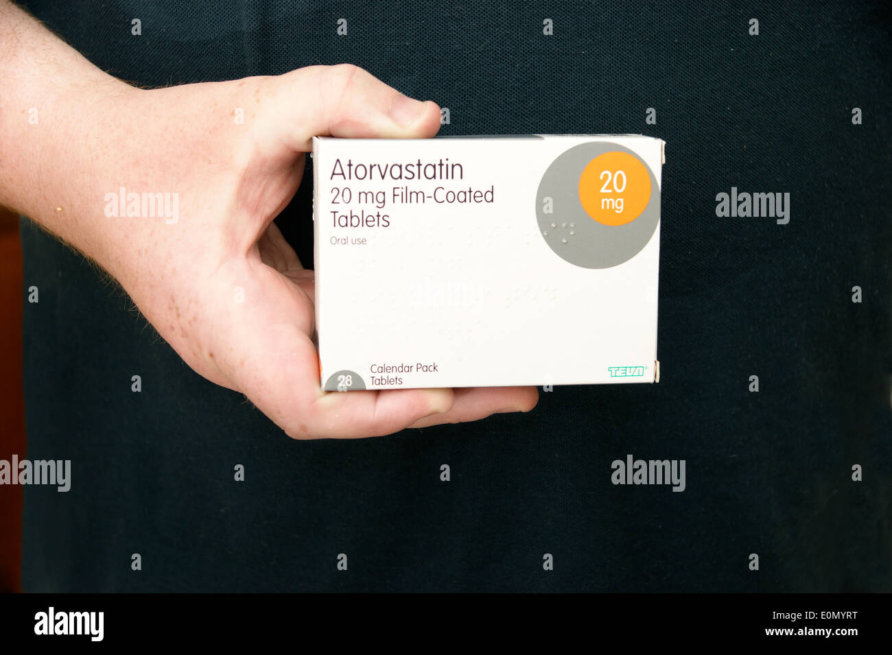 Man holding a box of Atorvastatin tablets (statins) Stock Photo