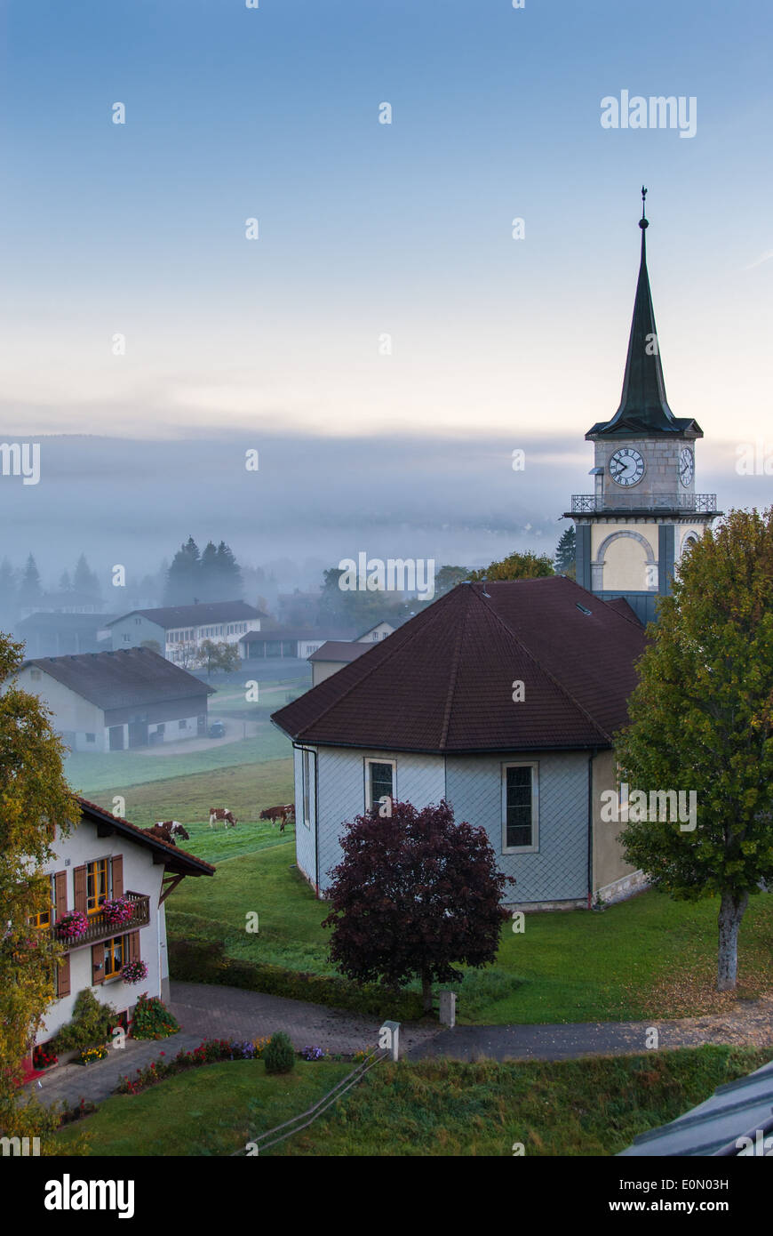 View of Le Brassus, a little village in the northern Switzerland, with a thick fog early in the morning in a winter day. Stock Photo