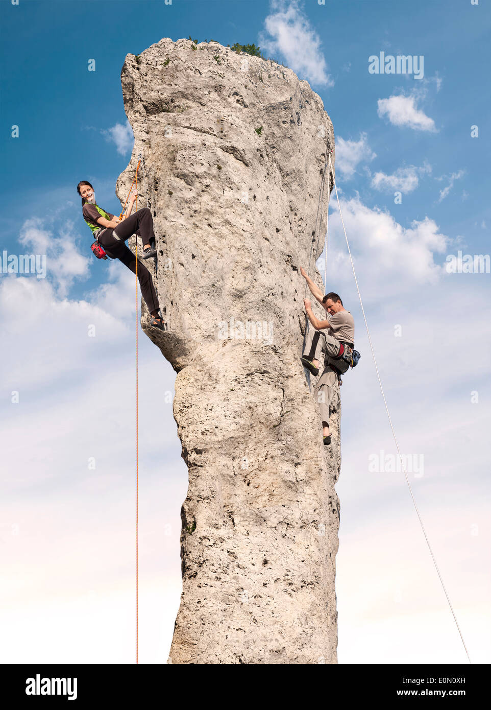 Climbers in action, young woman and man climbing difficult rock. Stock Photo
