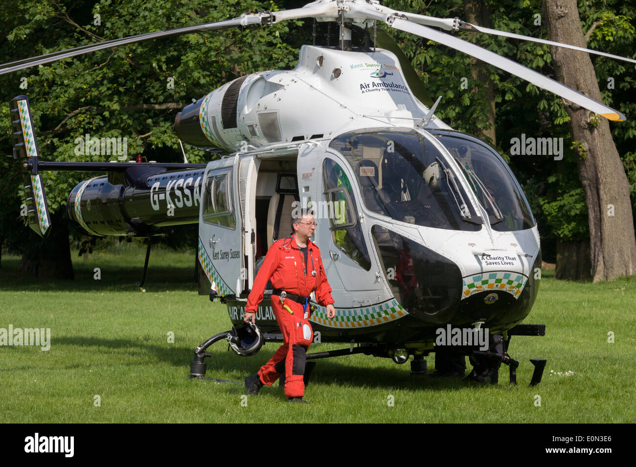 MD902 Explorer helicopter doctor crew from the Kent, Surrey & Sussex Air Ambulance Trust on the ground in Ruskin Park after emergency flight to Kings College Hospital in south London. Stock Photo