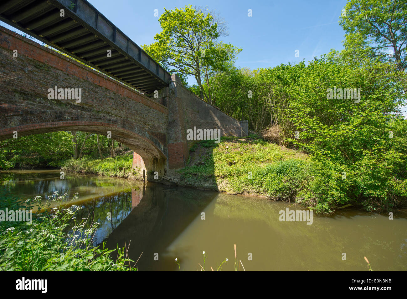 Rudgwick, West Sussex UK, 16th May, 2014. Sunlit slow flowing River Arun runs under a two-tiered railway bridge built in 1865. The bridge now carries the Downs Link Trail over the Arun and is surrounded by deciduous woodland Credit:  Malcolm Park editorial/Alamy Live News Stock Photo