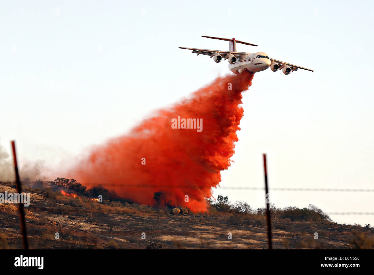 A firefighting tanker aircraft drops fire retardant chemicals on the Tomahawk fire May 14, 2014 around Camp Pendleton, California. Stock Photo