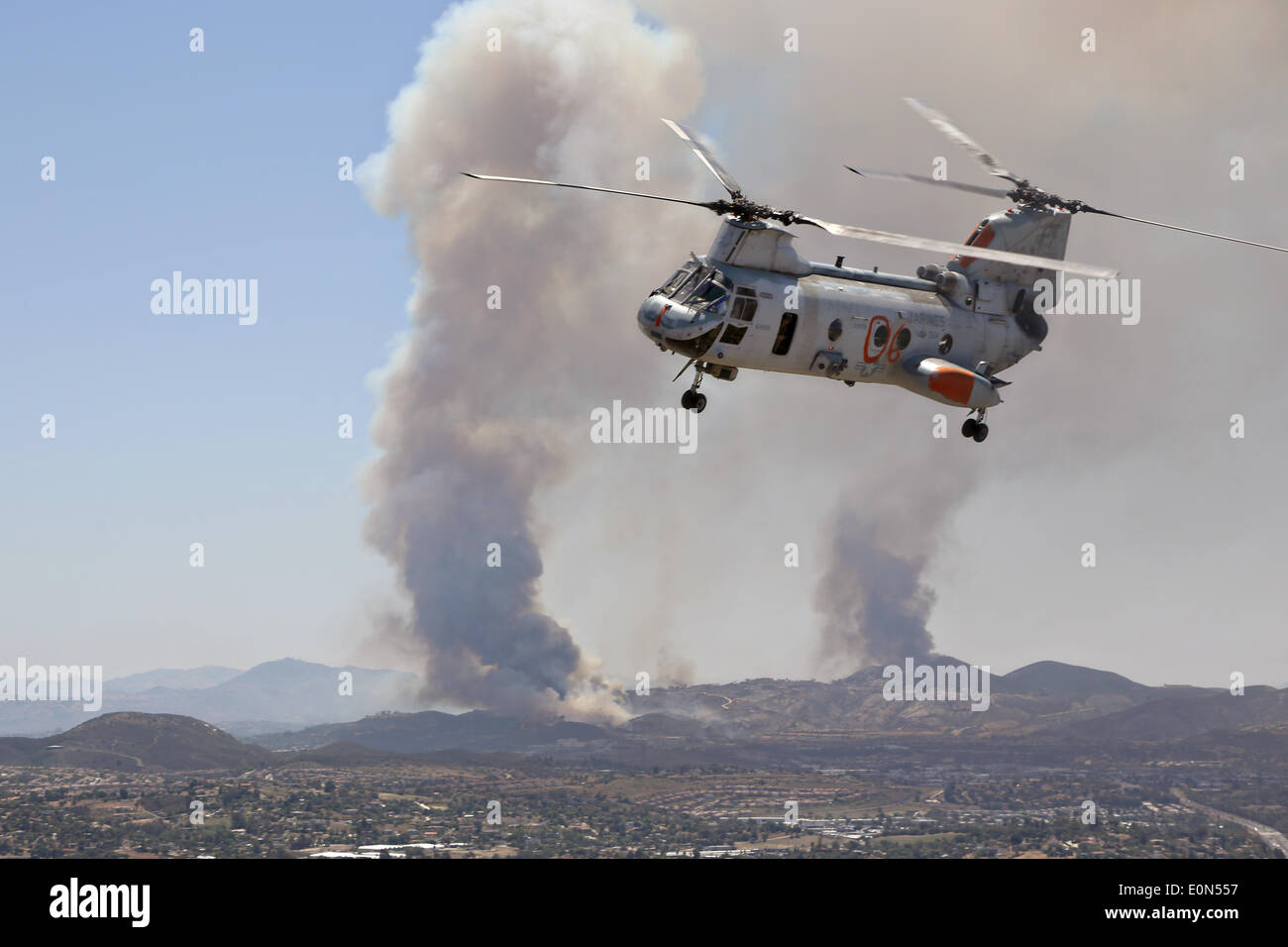 A US Marine Corps CH-46 Sea Knight helicopter help fight the Cocos wildfire as it burns the foothills destroying home May 15, 2014 around San Marcos, California.  Evacuations forced more than 13,000 people from their homes as the fire burned across San Diego County. Stock Photo
