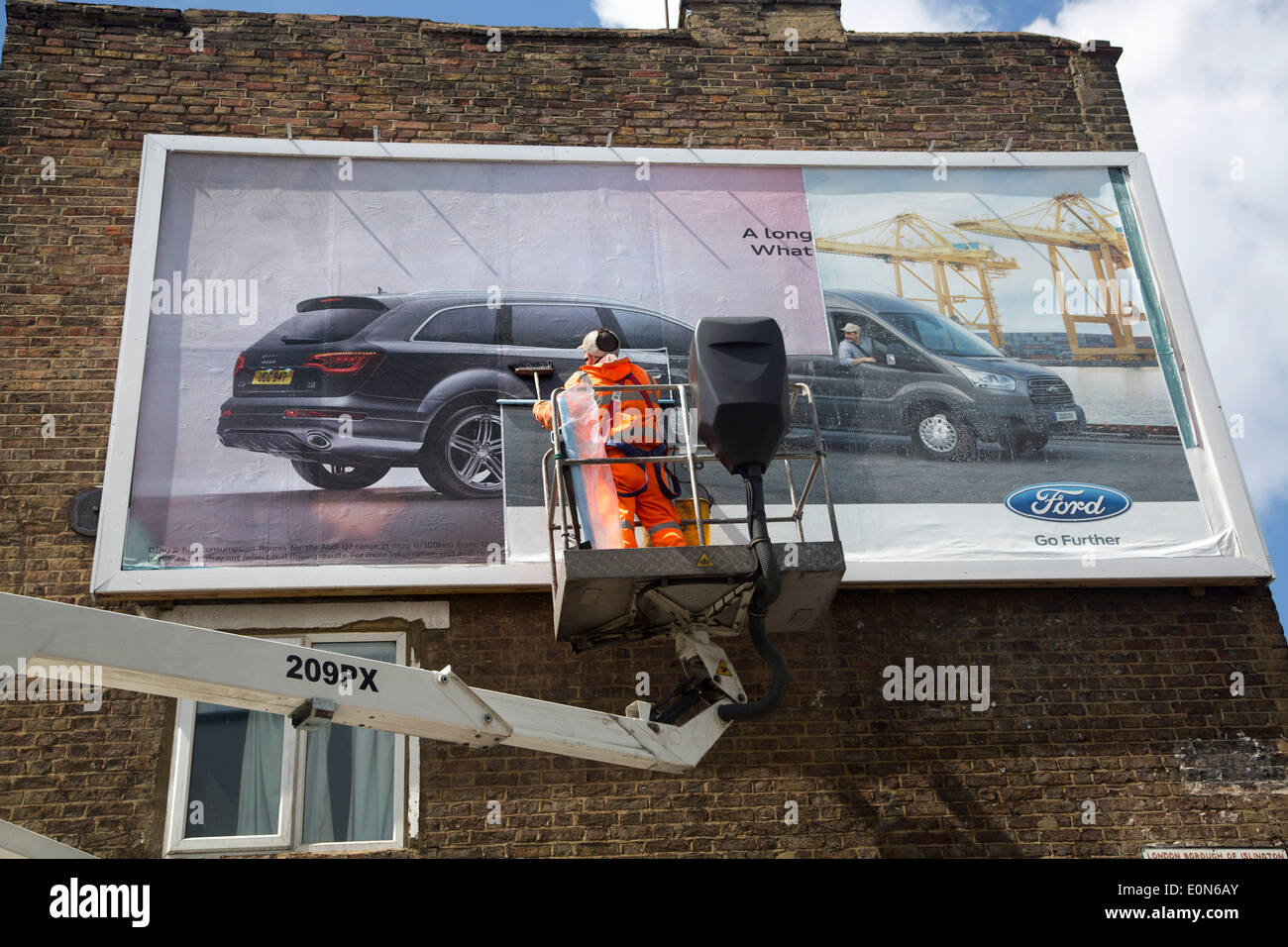 Bill poster stick up new advertisement on hoarding Stock Photo