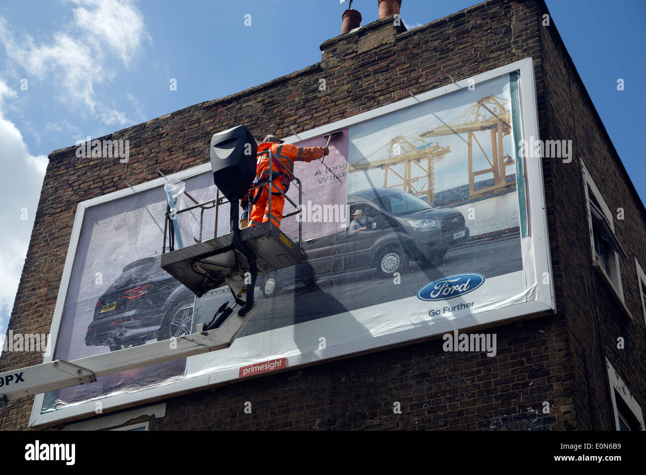 Bill poster stick up new advertisement on hoarding Stock Photo