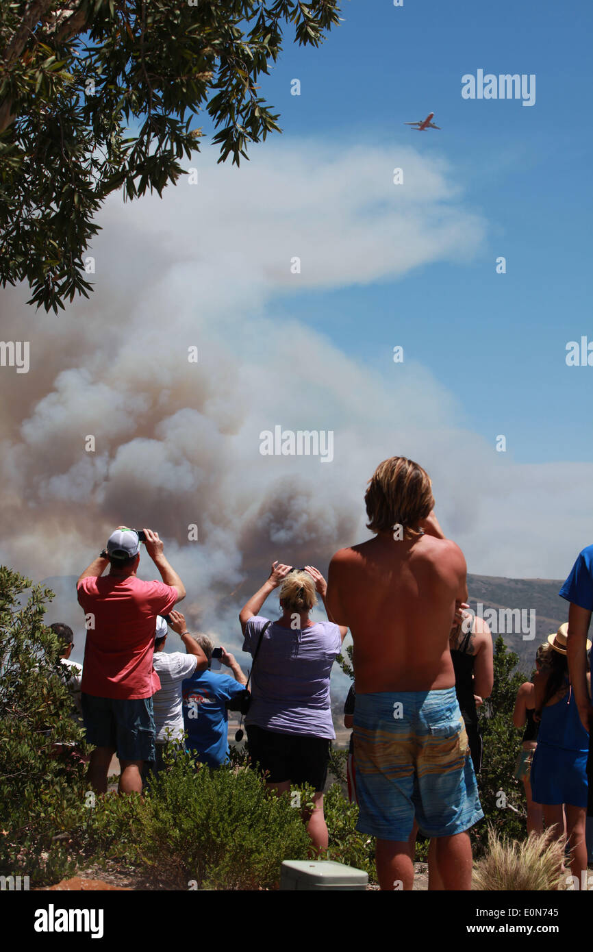 San Clemente, California, USA. 16th May, 2014. San Clemente residents in watch and take pictures with cellphones of fire fighting aircraft as the Las Pulgas wildfire burns inside Camp Pendleton marine Base. The wildfire in the western region of Camp Pendleton has grown to 8,000 acres burned, base officials confirmed, known as the Las Pulgas Fire, is 5 percent contained, officials said. California firefighters have continued to battle wildfires, which have scorched more than 11,000 acres and caused thousands to evacuate. Credit:  ZUMA Press, Inc./Alamy Live News Stock Photo