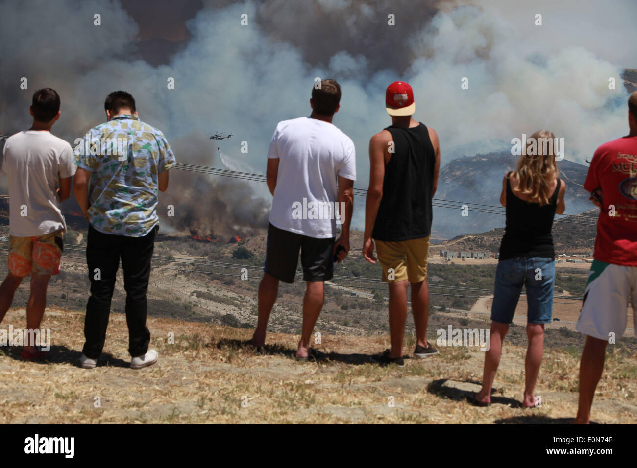 San Clemente, California, USA. 16th May, 2014. San Clemente residents watch fire fighting helicopters douse water on the Las Pulgas wildfire inside Camp Pendleton marine Base. The wildfire in the western region of Camp Pendleton has grown to 8,000 acres burned, base officials confirmed, known as the Las Pulgas Fire, is 5 percent contained, officials said. California firefighters have continued to battle wildfires, which have scorched more than 11,000 acres and caused thousands to evacuate. Credit:  ZUMA Press, Inc./Alamy Live News Stock Photo