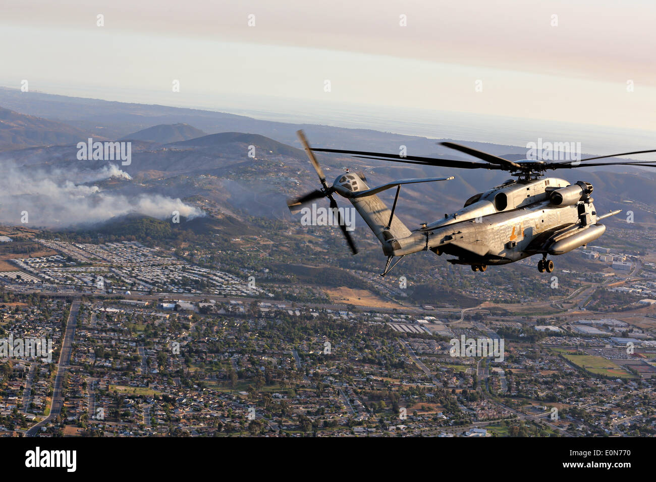 A US Marine Corps CH-53D Sea Stallion helicopter approaches the Cocos wildfire to assist in firefighting May 15, 2014 around San Marcos, California. Evacuations forced more than 13,000 people from their homes as the fire burned across San Diego County. Stock Photo