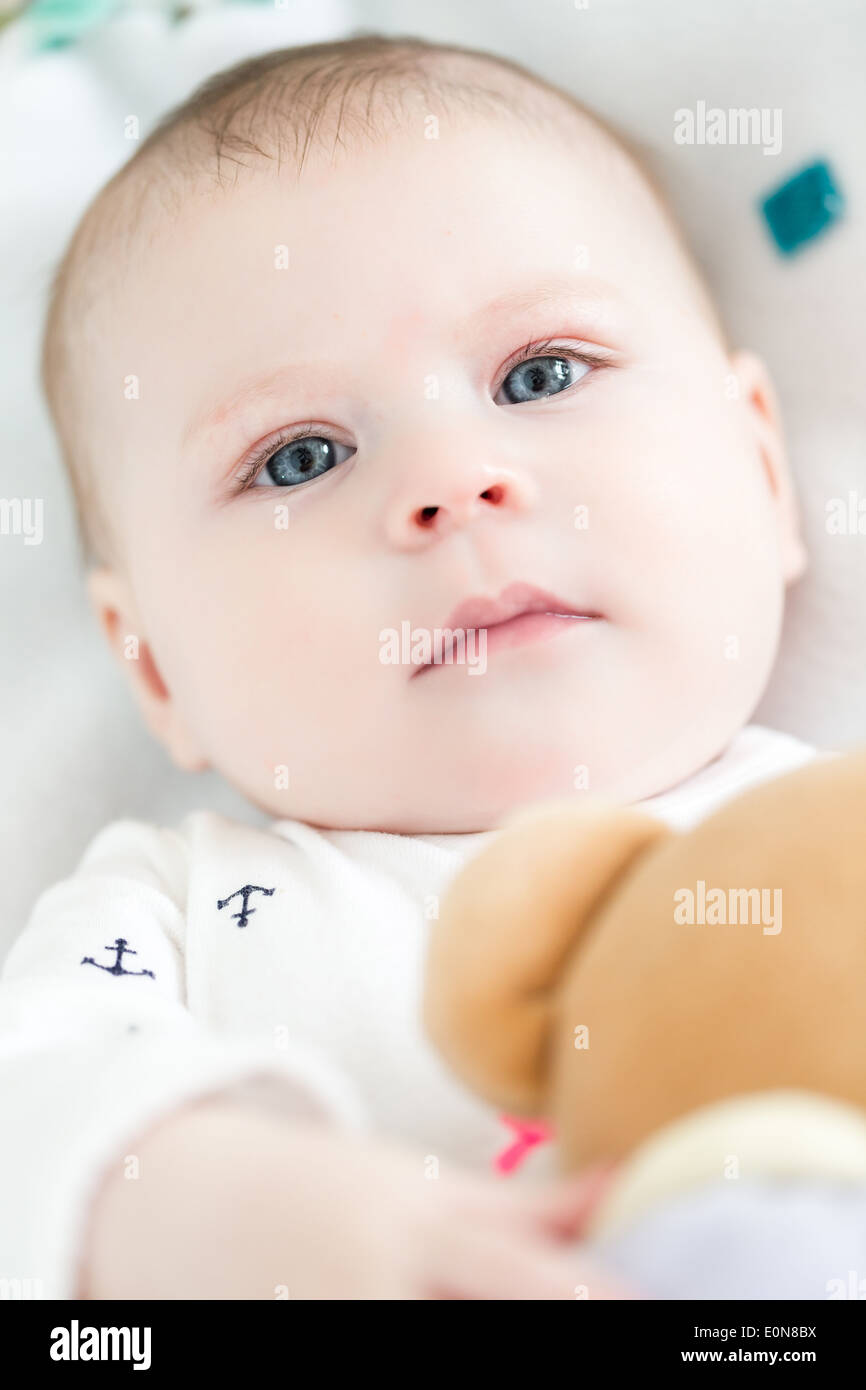 Baby girl playing with her teddy bear on a blanket Stock Photo - Alamy